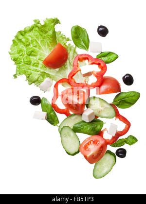 flying salad isolated in white - red tomatoes, pepper, cheese, basil, cucumber and olives Stock Photo