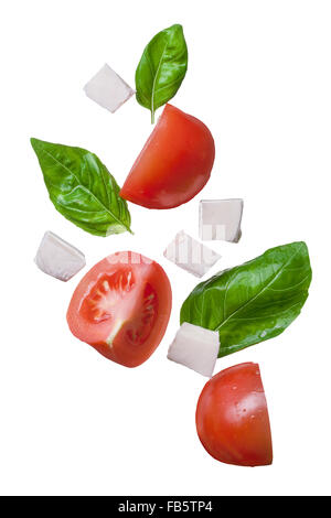 falling red tomatoes, mozzarella and basil isolated on white - caprese, traditional italian ingredients Stock Photo