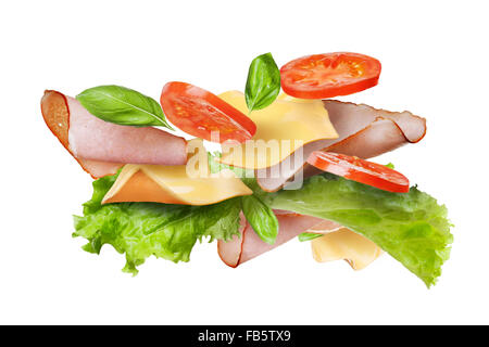 Ingredients for sandwich falling in the air isolated on white - slices of fresh tomatoes, ham, cheese and lettuce Stock Photo