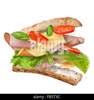 Sandwich with falling ingredients in the air isolated on white - slices of fresh tomatoes, ham, cheese and lettuce Stock Photo