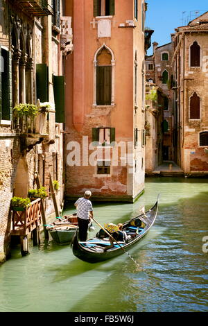 Gondolier flowing gondola, Venice canal, Veneto, Italy, UNESCO Stock Photo
