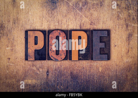 The word 'Pope' written in dirty vintage letterpress type on a aged wooden background. Stock Photo