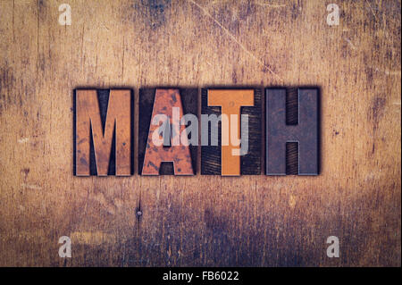 The word "Math" written in dirty vintage letterpress type on a aged wooden background. Stock Photo