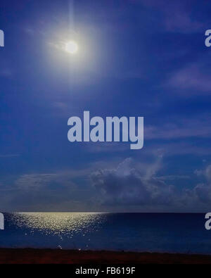 A full moon at night shines over the Caribbean casting a glow on the sea off St. Croix, U.S. Virgin Islands. Stock Photo