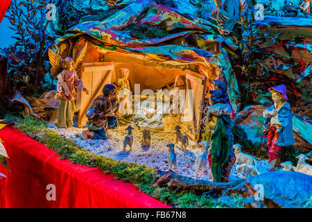 Christmas Nativity scene, the Blessed Virgin Mary and Saint Joseph watch over the Holy Child Jesus as the ox and the donkey are warming while the three wise men bring gifts of gold, frankincense and myrrh Stock Photo