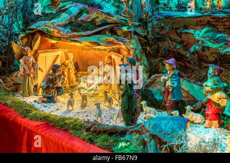 Christmas Nativity scene, the Blessed Virgin Mary and Saint Joseph watch over the Holy Child Jesus as the ox and the donkey are warming while the three wise men bring gifts of gold, frankincense and myrrh Stock Photo