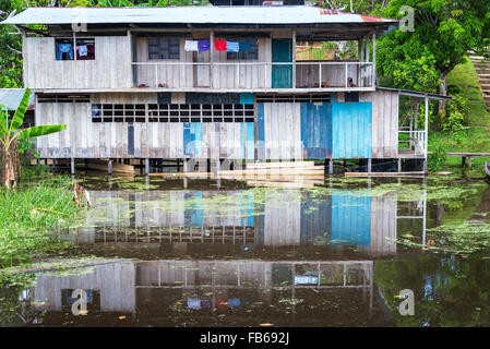 House being reflected in the Amazon River in Puerto Narino, Colombia Stock Photo