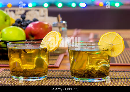two cups of green tea with lemon and fruit on the table Stock Photo