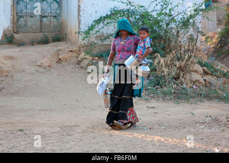 Kacchi Rabari (Desi), Laharia Village, woman carrying her son, Kutch District, Gujarat, India Stock Photo