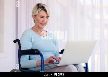 modern disabled middle aged woman using laptop Stock Photo