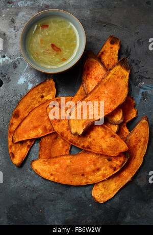 Homemade crispy sweet potato chips served with hot chilli sauce Stock Photo