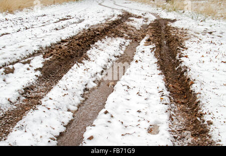 Bad road conditions: snow, ice and mud on a country road Stock Photo