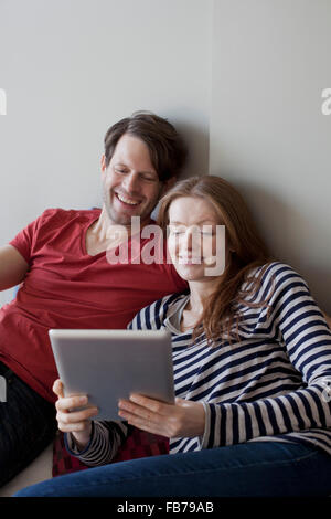 Couple using digital tablet, smiling Stock Photo