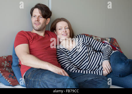 Couple lying on sofa Stock Photo