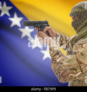 Man with gun in hand and national flag on background series - Bosnia and Herzegovina Stock Photo