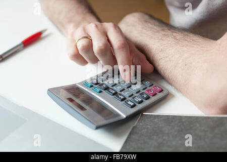 Cropped image of man using calculator at table Stock Photo