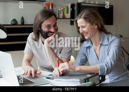 Happy couple using laptop while working from home Stock Photo