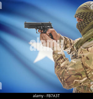 Man with gun in hand and national flag on background series - Somalia Stock Photo