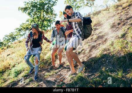 Low angle view of friends climbing mountain in forest Stock Photo