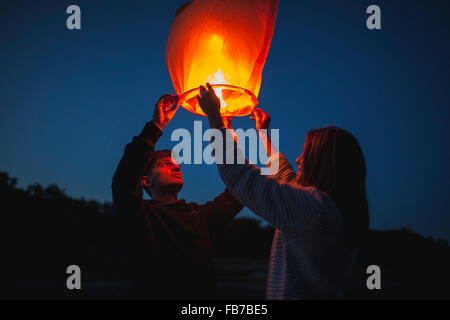 Low angle view of hikers releasing paper lanterns Stock Photo