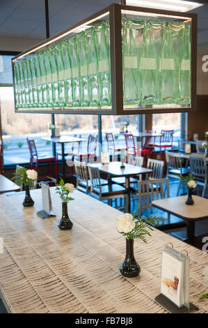 Chick-fil-A Muskogee's community table and Coca-Cola bottle lighting fixture in their indoor dining area. Stock Photo