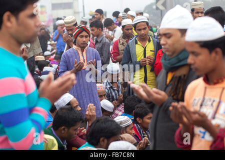 DHAKA, BANGLADESH 10th January 2016: Bangladeshi Muslim devotees attend the Akheri Munajat concluding prayers on the third day of Biswa Ijtema, the second largest Muslim congregation after the Hajj, at Tongi Railway station in Tongi 20 km from Dhaka on January 10, 2016. Around two million Muslims from Bangladesh and abroad observed the three-day congregation with prayers on the banks of the Turag River. Stock Photo