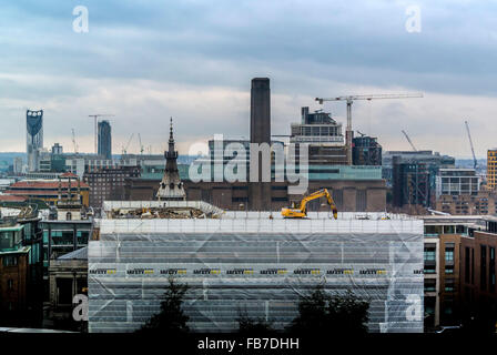 JCB Digger Excavator working on roof of building in central London UK with Tate Modern in background. Stock Photo