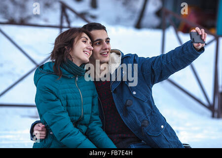 Loving young couple taking selfie through smart phone during winter Stock Photo