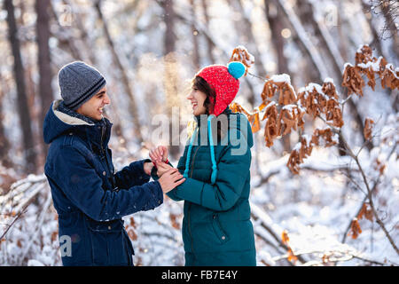 Playful young couple holding hands during winter Stock Photo