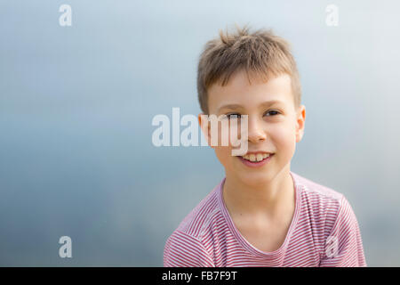 Thoughtful boy smiling while looking away outdoors Stock Photo