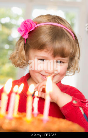 Cute girl looking at birthday cake Stock Photo