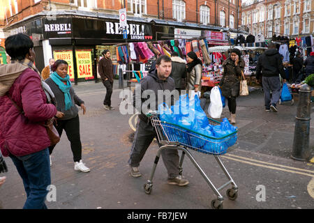 People shopping in Brixton West Indian outdoor market Lambeth South London Stock Photo