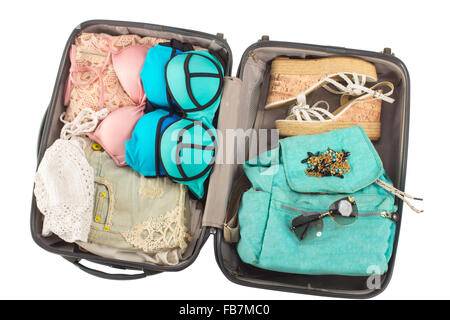 Packed, opened suitcase full of vacation items. Stock Photo