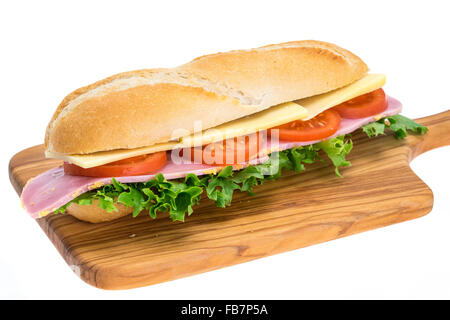 A fresh ham, cheese and salad sandwich in a crusty bread roll on a wooden chopping board - studio shot with a white background Stock Photo