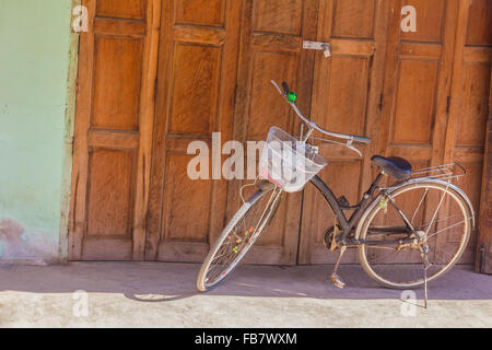 old classic bicycle parked in front of old wood plank wall Stock Photo