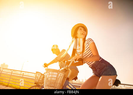 Happy young couple going for  bicycle ride on a sunny day Stock Photo