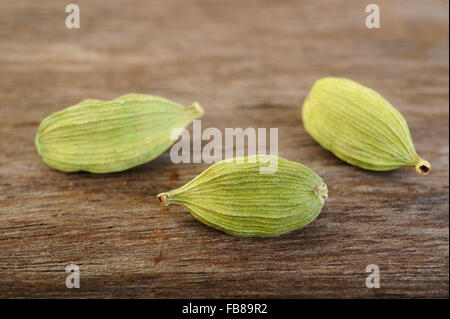 green cardamom pods on wooden background Stock Photo