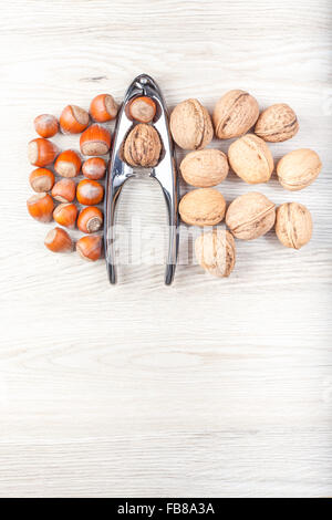 Nuts and nutcracker on wooden background, space for text. Stock Photo