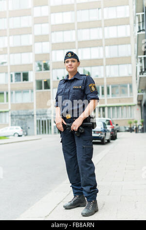 Sweden, Uppland, Stockholm, Policewoman standing on sidewalk