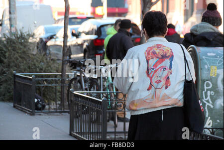New York, USA. 11th Jan, 2016. A fan of late British musician David Bowie wears a jacket featuring the cover of Bowie's 1973 album 'Aladdin Sane' in the SoHo district of New York, USA, 11 January 2016. Bowie died from cancer on 10 January 2016. Photo: CHRISTINA HORSTEN/dpa/Alamy Live News Stock Photo