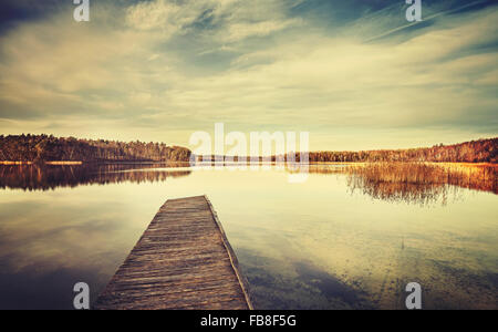 Vintage stylized picture of a lake and wooden pier. Stock Photo