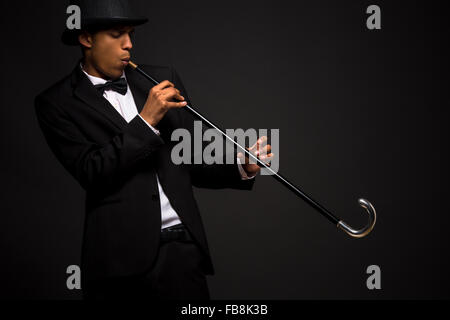 Handsome man in top hat posing with cane Stock Photo