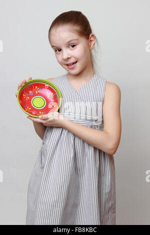 Emotional little girl holding colorful ceramic bowl Stock Photo