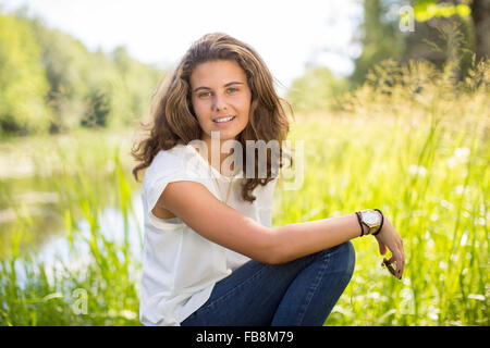 Beautiful blonde teen girl 13-14 year old wearing stylish clothes posing in  autumn park. Looking at camera Stock Photo - Alamy