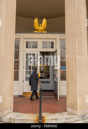 ARLINGTON, VIRGINIA, USA - Woman entering U.S. Post Office, and gold leaf eagle and name over door. in Clarendon neighborhood. Stock Photo