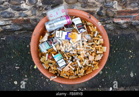 cigarette butts and packets outside pub restaurant Stock Photo