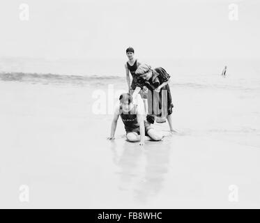 Two Young Men and Woman Having Fun at Beach, Coney Island, New York, USA, 1900 Stock Photo