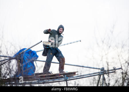 Upton, Cheshire. 12th Jan, 2016. Protestor on a tower playing a drum as bailiffs and policemove in to evict the camp. Credit:  Jason Smalley / Alamy Live News Stock Photo
