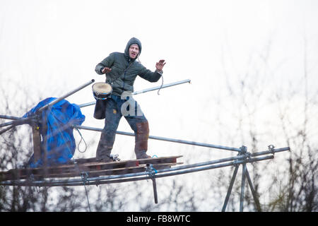 Upton, Cheshire. 12th Jan, 2016. Protestor on a tower playing a drum as bailiffs and policemove in to evict the camp. Credit:  Jason Smalley / Alamy Live News Stock Photo