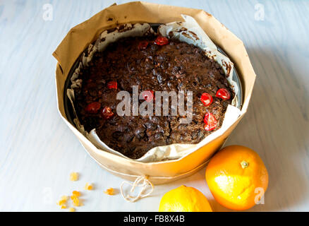 Christmas cake has to be baked for hours so it is wrapped in brown paper to protect from burning. Stock Photo
